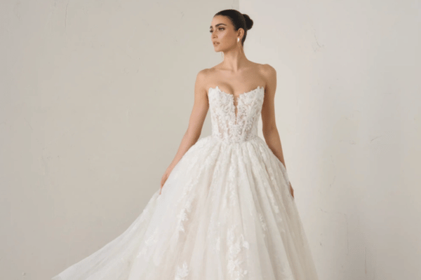 Bride wearing a strapless ball gown wedding dress with a lace appliqu&eacute; bodice, sweetheart neckline, and full tulle skirt, creating a romantic bridal silhouette.