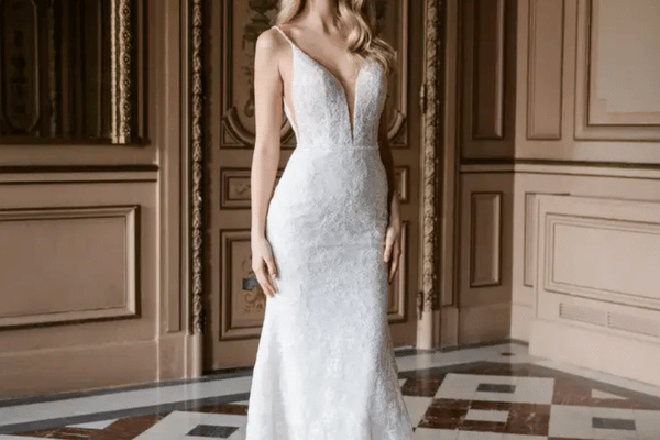Bride wearing a fitted lace sheath wedding dress with thin straps and a plunging V-neckline, creating an elongated silhouette ideal for a petite frame.