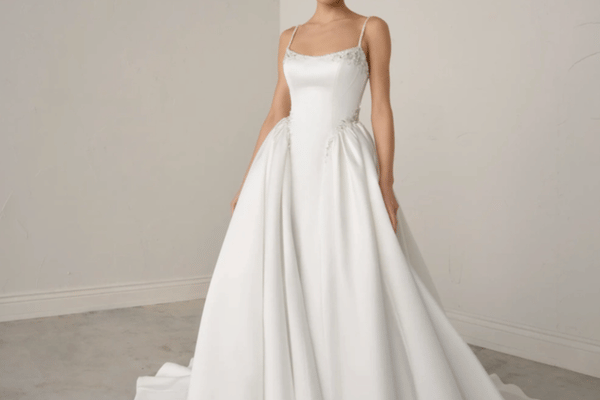 Bride wearing a simple satin ball gown with spaghetti straps and a structured bodice, showcasing a balanced silhouette for petite brides.