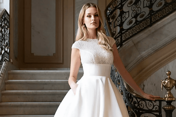 A high neckline wedding gown worn by a beautiful bride going down the stairs