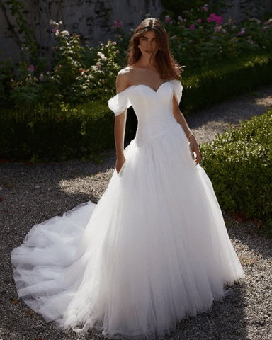 A bride standing outdoors in her tulle ball gown wedding dress