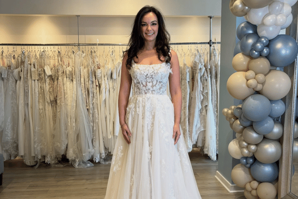 Bride wearing a floral lace A-line wedding dress in a bridal boutique
