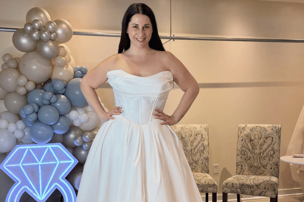Bride wearing strapless sample sale wedding dress with full skirt in bridal boutique fitting area