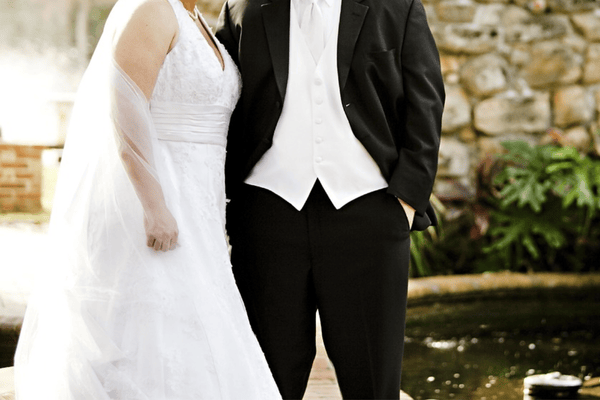 A groom with her bride wearing her empire waist wedding dress