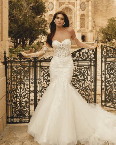 A bride in her mermaid silhouette wedding dress leaning on the fence
