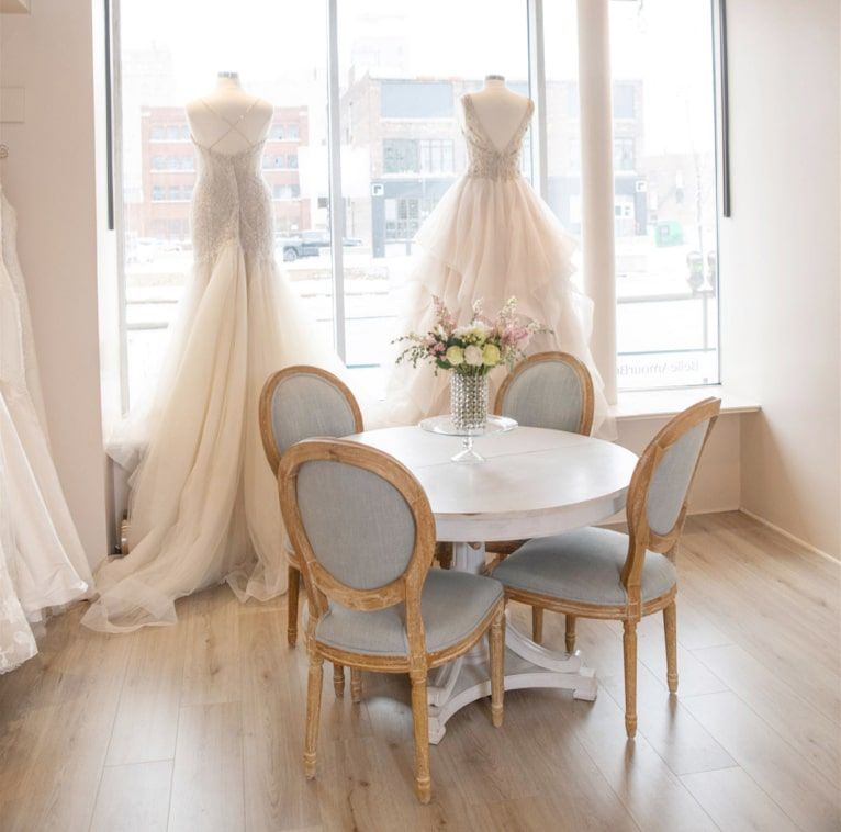 Bridal store image with dresses and flowers on a table top